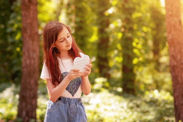 Het meisje in een wit T-shirt. Tiener meisje op de achtergrond van de aard van het bos. - Foto, afbeelding