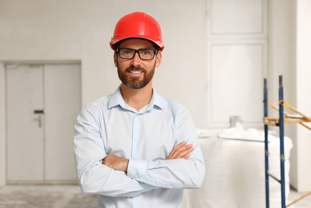 Portrait of professional engineer in hard hat indoors - Fotó, kép