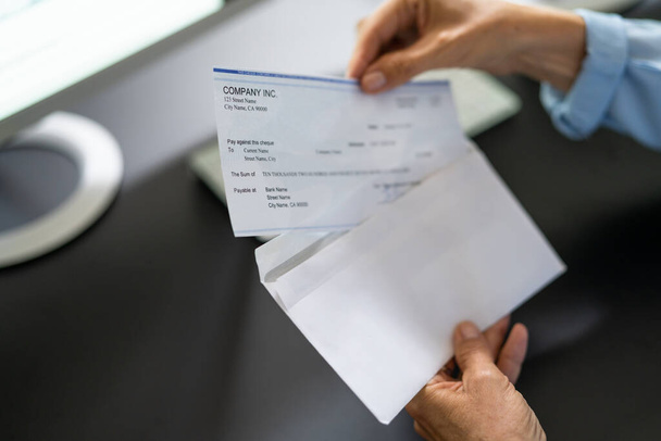 Payroll Cheque In Envelope. Woman Hand Holding Paycheck - Valokuva, kuva