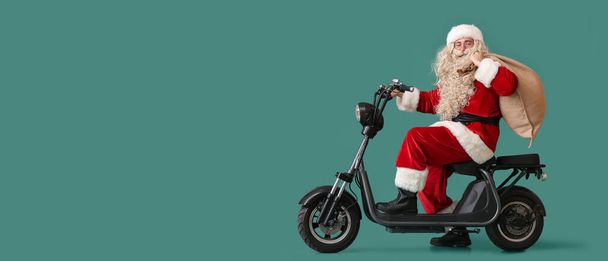 Santa Claus with sack bag and bike on green background with space for text - Photo, Image