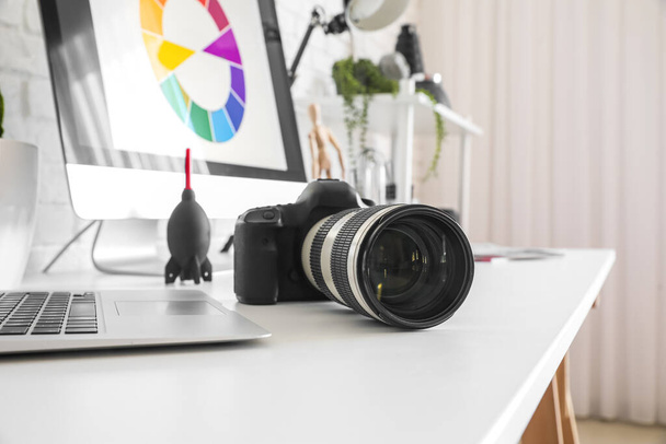 Μοντέρνα φωτογραφική μηχανή στο τραπέζι στο στούντιο, closeup - Φωτογραφία, εικόνα
