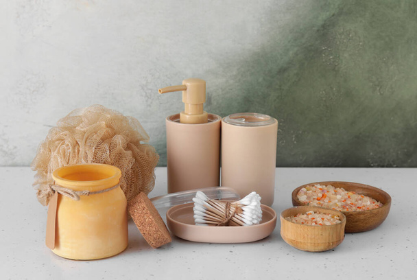 Bath accessories with bowls of sea salt on table near color wall - Photo, Image