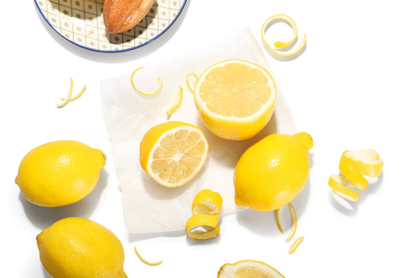 Limones frescos maduros y cáscara sobre fondo blanco - Foto, Imagen