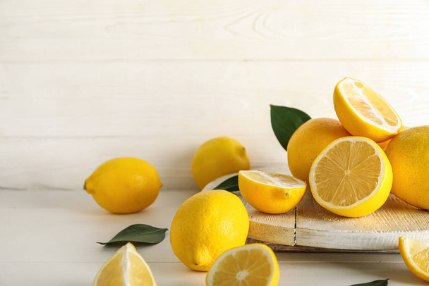 Доска из свежих лимонов на светлом деревянном столе - Фото, изображение