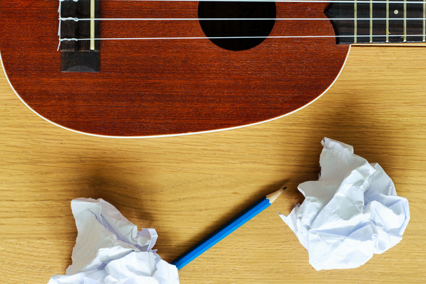 ukelele guitarra con trozos de papel y lápiz
 - Foto, imagen