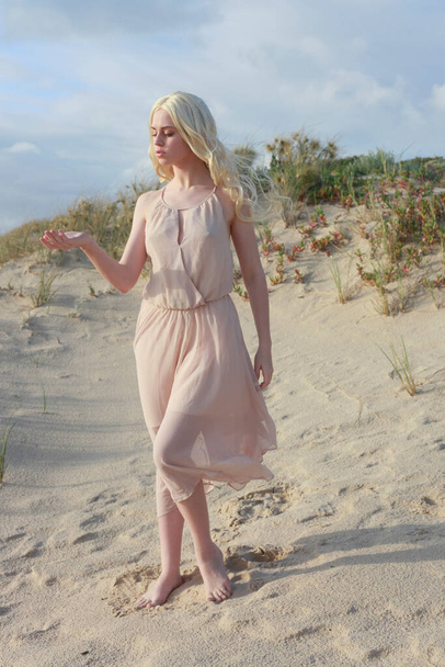 täyspitkä muotokuva kaunis nuori nainen pitkät hiukset yllään yksinkertainen mekko virtaa tuulessa, tyylikäs aiheuttaa. Ocean Beach tausta kultainen auringonlasku valaistus. - Valokuva, kuva