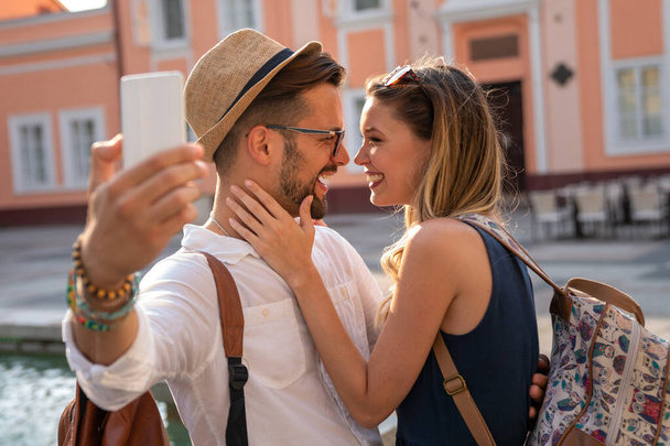 Happy traveling young couple taking selfie, having fun on vacation. People technology happiness concept. - Fotografie, Obrázek