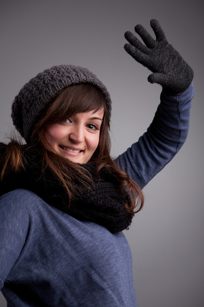 дівчина махає на камеру з теплим капелюхом шарфом і рукавичками
 - Фото, зображення