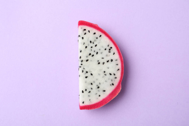 Slice of delicious dragon fruit (pitahaya) on violet background, top view - Фото, зображення