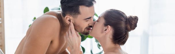 shirtless man with muscular torso kissing young girlfriend at home, banner - Photo, Image