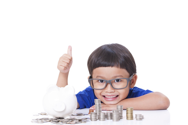 Cute boy with a stack of coins and showing thumb up sign. - Foto, immagini