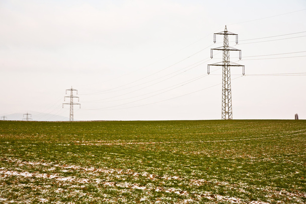 Mark of tyre in field with electrical tower in wintertime - Zdjęcie, obraz