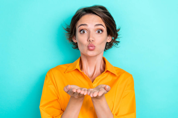 Portrait of girlish adorable gorgeous girl bob hairstyle wear orange shirt send kiss on camera to you isolated on teal color background. - Photo, Image