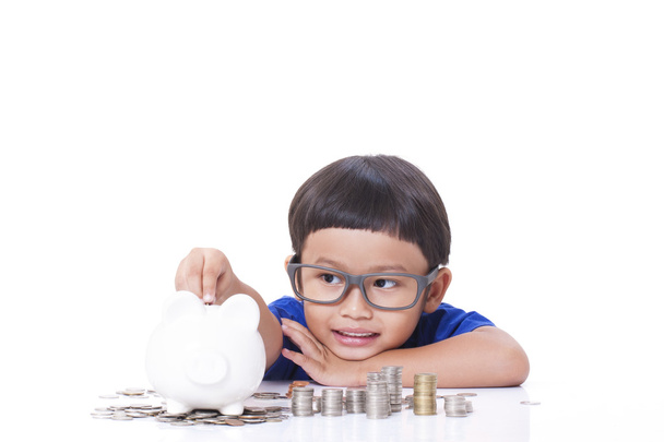 Cute boy saving money in piggy bank - Foto, immagini