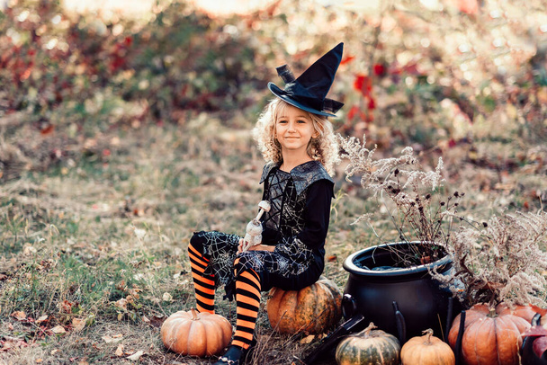 Beautiful girl witch. little girl in which costume celebrate Halloween outdoor and have fun. Kids trick or treating. girl witch with magic Book of spells. - Foto, Imagem