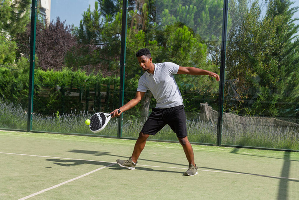Zwarte sportman die paddle tennis speelt - Foto, afbeelding