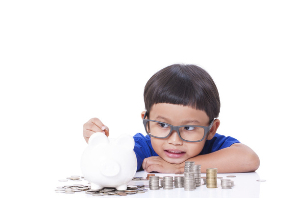 Cute boy saving money in piggy bank - Fotografie, Obrázek