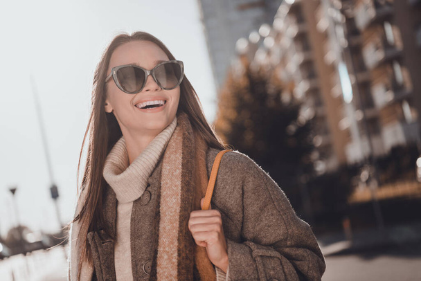Photo of positive excited woman wear grey coat dark glasses smiling enjoying sunshine walking home outside urban city street. - Valokuva, kuva
