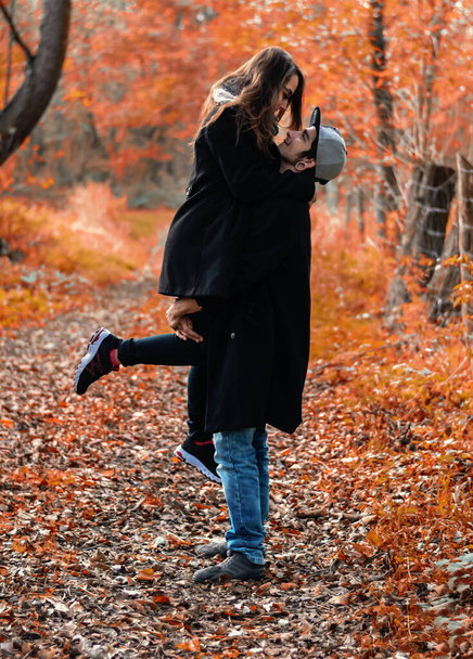 boy holds his girlfriend in his arms, autumn love scene. High quality photo - Fotoğraf, Görsel
