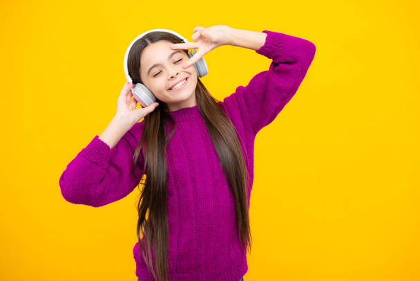 Stylish teenage girl listening to music with headphones. Kids lifestyle concept. Wireless earphones - Photo, image