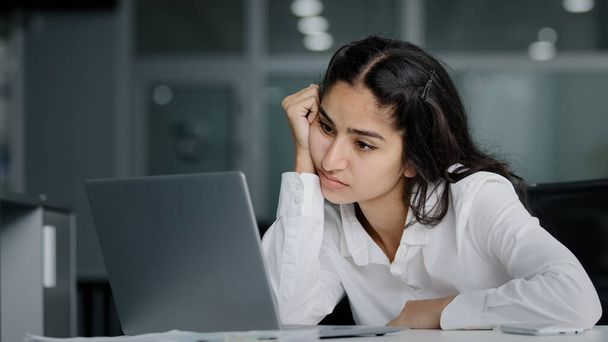 Нудно сумна лінива молода індійська жінка менеджер сидить в офісі не мотивований нецікавий в нудному ноутбуці, працює над перевантаженою втомленою сонною бізнес-леді відчуває втому виснажену роботу
 - Фото, зображення