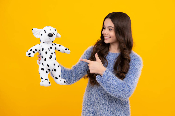 Teen girl child in casual wear holding plush toy isolated on yellow background, happy childhood. Happy teenager, positive and smiling emotions of teen girl - Foto, Bild