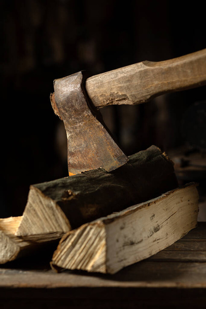 An ax is cut into a log of firewood for a firebox on a wooden texture - Fotoğraf, Görsel