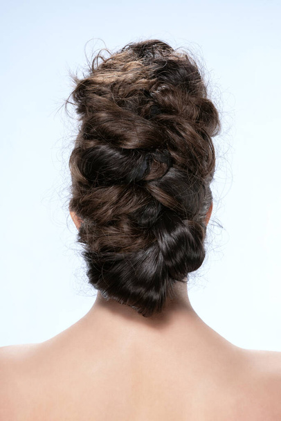 Back view of young woman. Portrait of a nude young white woman with curly hair. Dark hair. Stylish hairdo. Isolated on a light background - Φωτογραφία, εικόνα