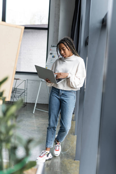 African american businesswoman in casual clothes using laptop in modern office  - Photo, Image