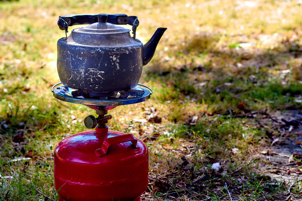 Lähikuva boilng vanha vedenkeitin kannettava camping kaasuliesi punainen propaani ilmapallo - Valokuva, kuva
