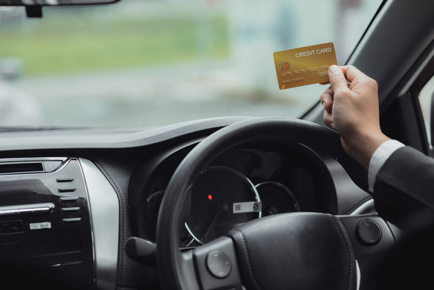 彼はガソリンスタンドに行きクレジットカードの請求書を支払い車で旅行安全運転交通ルールを尊重する彼のクレジットカードの請求書を支払う. - 写真・画像