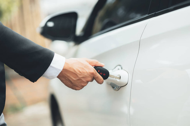 Man using car keys to open car doors to enter for commuting to work, using vehicles to travel safely on the road and respecting traffic rules. Safety driving concept. - Foto, Imagem