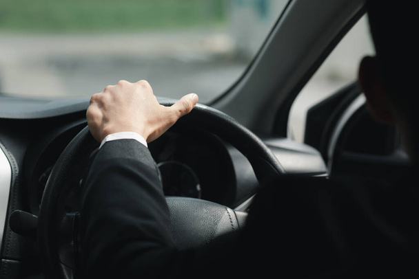 A man in a suit is driving a car to work, he is driving a car to work at the company. Vehicle driving concept. - Fotoğraf, Görsel