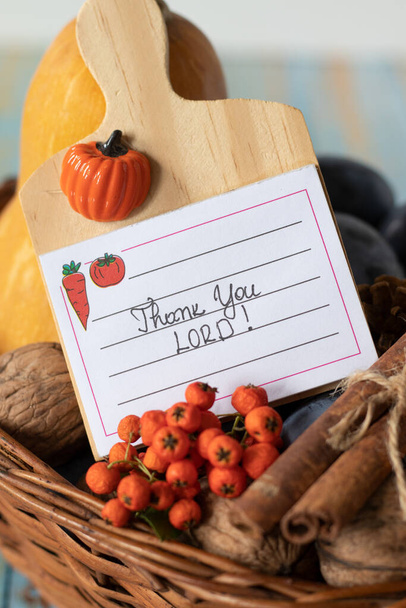 Danke, HERR, handgeschriebene Botschaft auf einem Zettel, der in einem Weidenkorb mit Herbstfrüchten liegt. Eine Nahaufnahme. Dankbarkeit und Lob für Gott, christliches Danksagungstagskonzept. - Foto, Bild