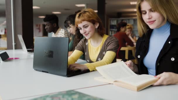 Νέοι και διαφορετικοί άνθρωποι που σπουδάζουν στη βιβλιοθήκη - έννοια της σχολικής εκπαίδευσης - Πλάνα, βίντεο