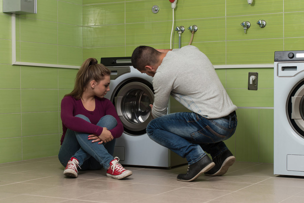 Young Couples Loading The Washing Machine In Room - Φωτογραφία, εικόνα
