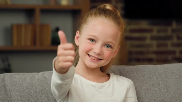 Portrét kavkazský šťastný spokojený blondýnka holčička malý pozitivní dítě dívá na kameru, aby palec nahoru jako a schválení gesto vše jemné pozitivní dobré emoce děti upřímné doporučení - Záběry, video
