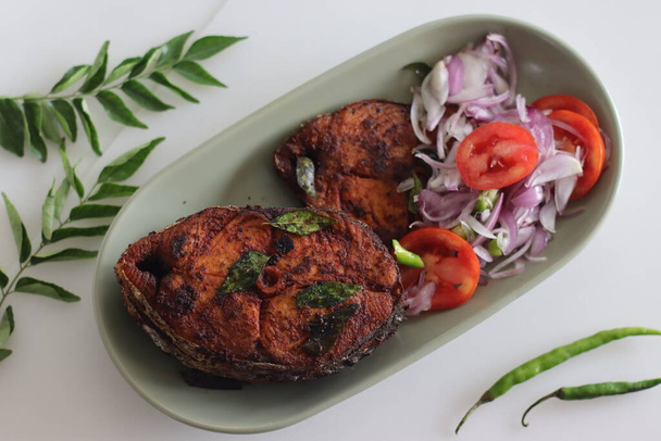 Рибний посуд Кріспі Сурмай. Shallow fried king fish in Kerala style served with Onion tomato salad called challas. Розстріляний на білому тлі - Фото, зображення