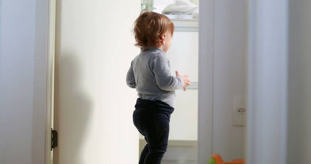 Baby standing by home bathroom, one year toddler stands observing - Foto, Bild