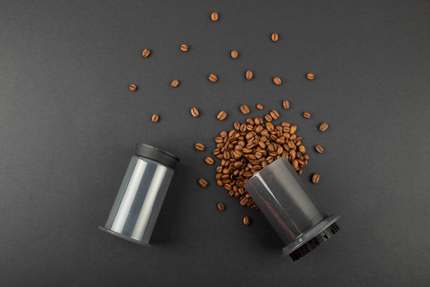 黒を背景にコーヒー豆とエアロプレス。Aeropressは醸造メーカーのコーヒーのための装置です。 - 写真・画像