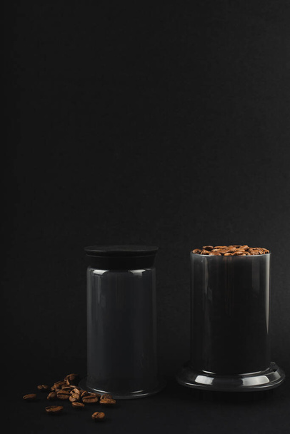 Aeropress con granos de café sobre fondo negro. Aeropress es un dispositivo para el café cervecero - Foto, Imagen