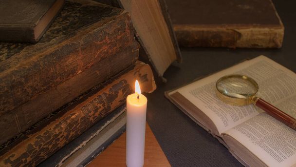 staré knihy na stole, čtení při svíčkách, lupa - Fotografie, Obrázek