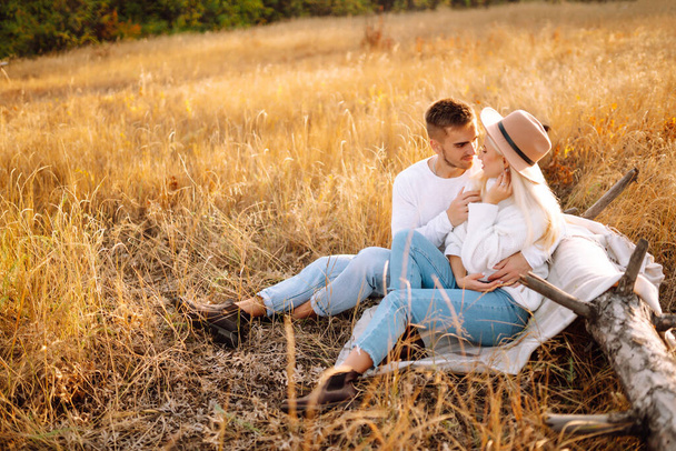 Young couple resting in nature. Autumn weather. Relaxation, youth, love, lifestyle concept. - Foto, afbeelding