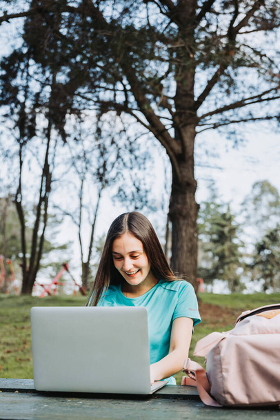 Estudante universitária rindo e usando seu computador no campus parque universitário. Foto de alta qualidade - Foto, Imagem