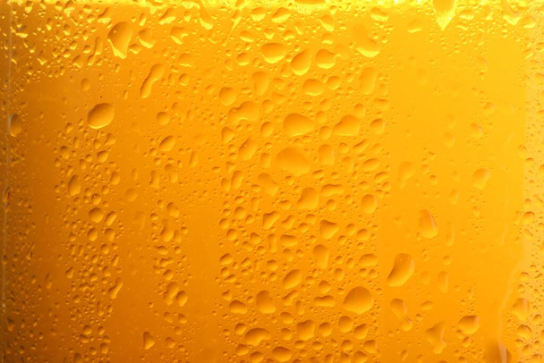 Glass of tasty cold beer with condensation drops as background, closeup - Foto, imagen