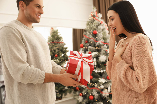 Happy couple with Christmas gift at home - Foto, imagen
