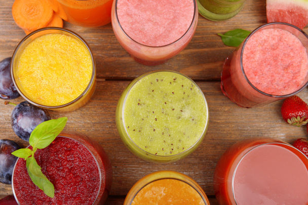 Glasses of tasty fresh juice, on wooden table. - Φωτογραφία, εικόνα