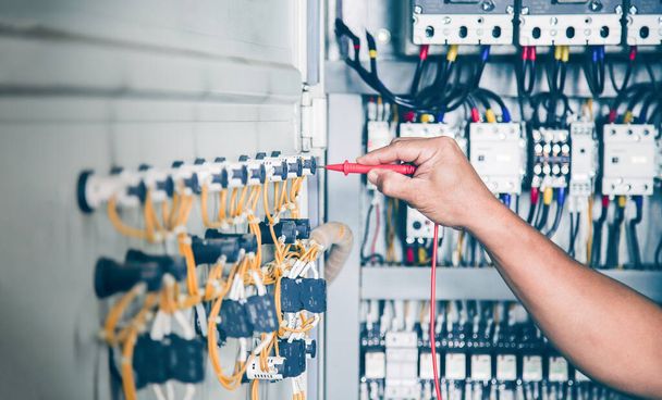 An electrical engineer is inspecting the operation of an electrical control cabinet. maintenance concept - Φωτογραφία, εικόνα