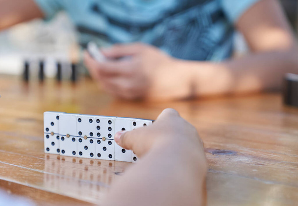 A family playing domino game in a wooden table. - Photo, image