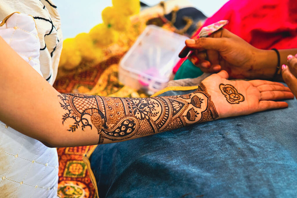 La aplicación de tatuaje de henna en las manos de una novia. Brown Colors of Henna Ink. Ceremonia Mehendi de formación india. - Foto, Imagen